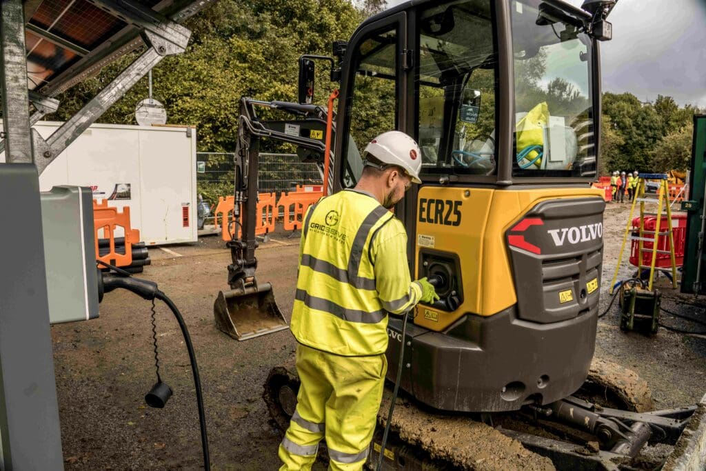 Worker unplugging fully-electric excavator at GRIDSERVE Electric Super Hub