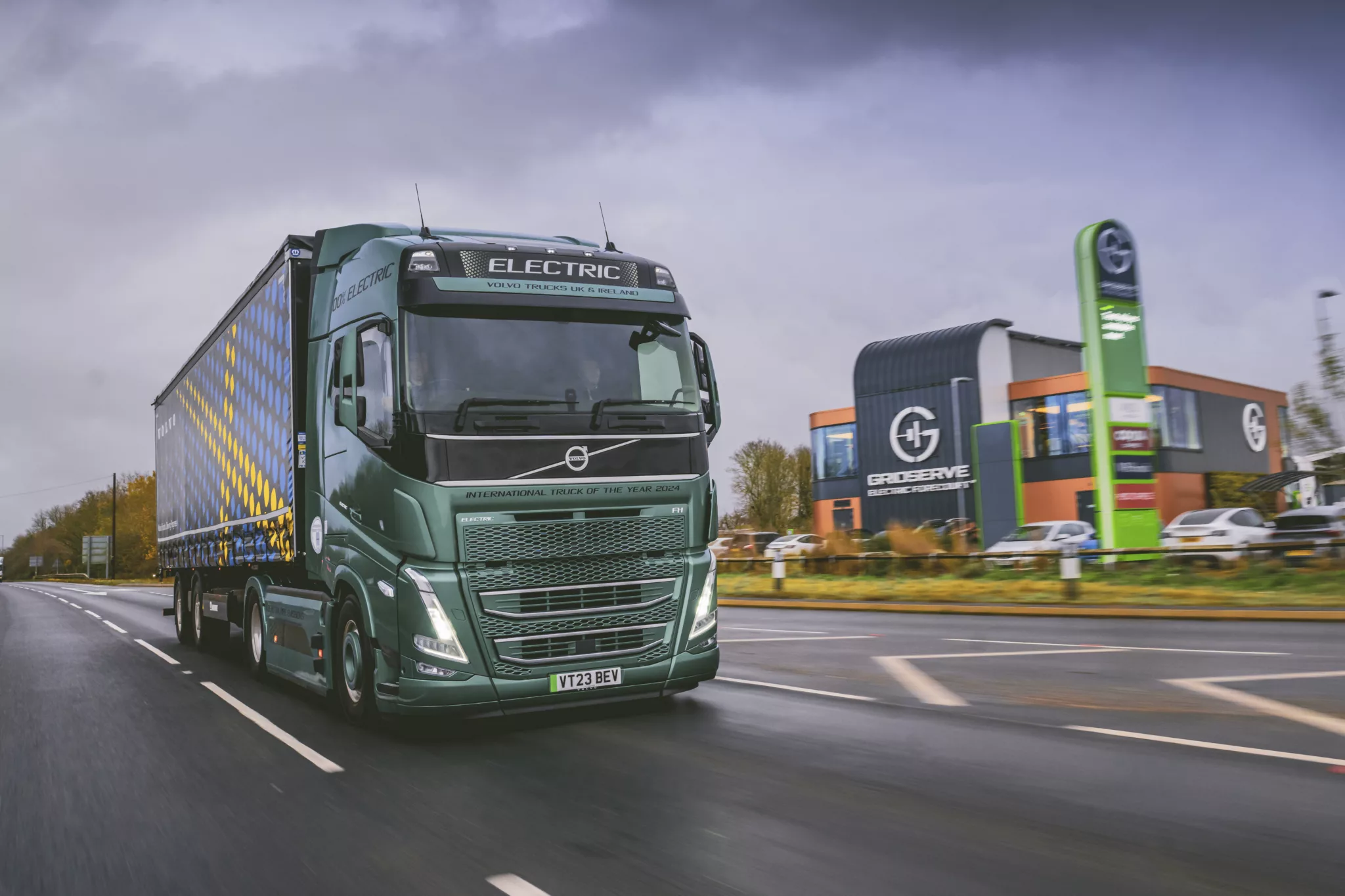 electric Volvo truck driving past GRIDSERVE Electric Forecourt