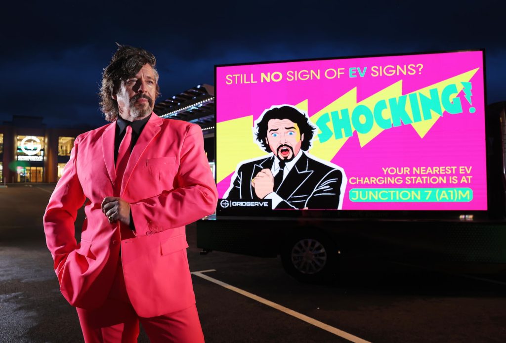 Laurence Llewelyn-Bowen stands in front of EV Charging Sign