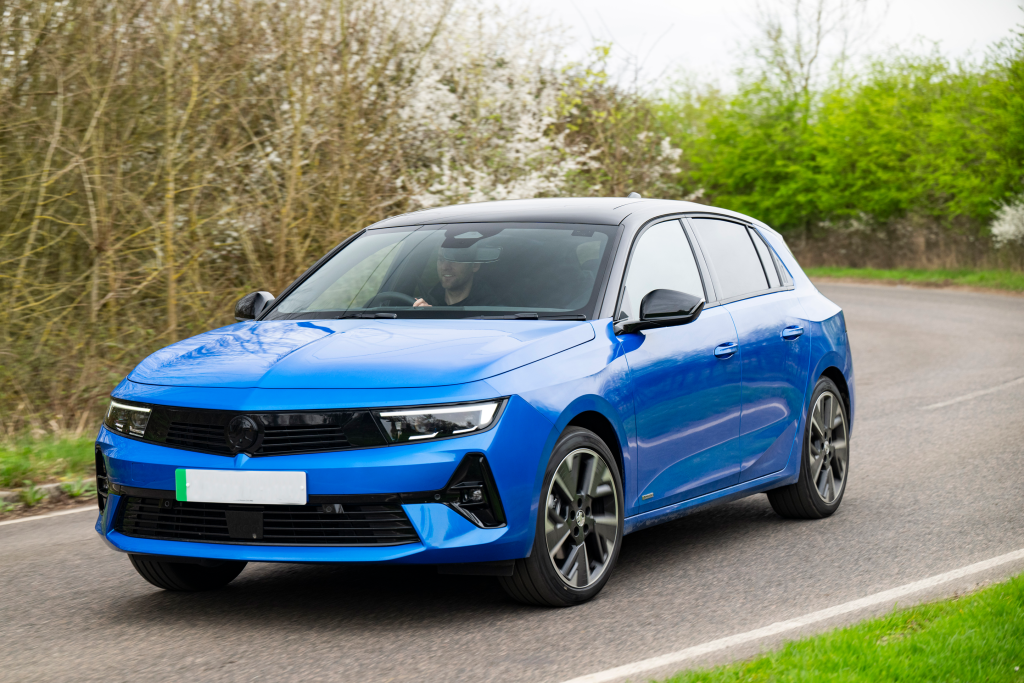 A blue car being driven on a country