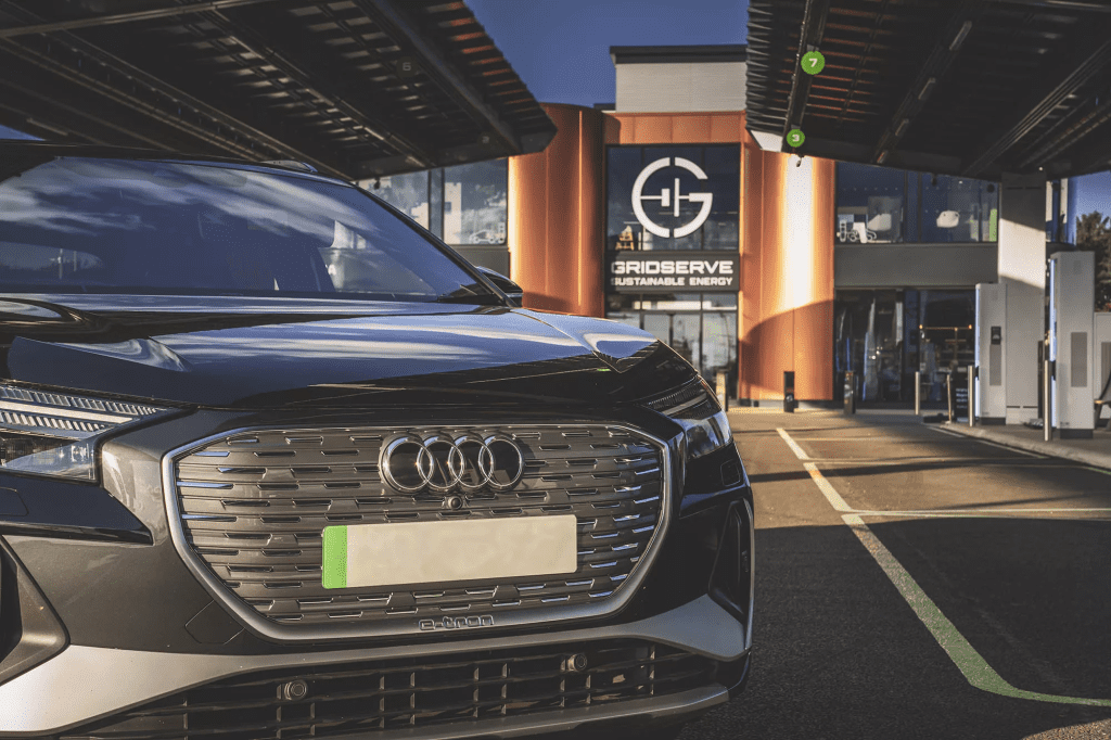 An Audi outside an Electric Forecourt. The green number plate is clearly visible.